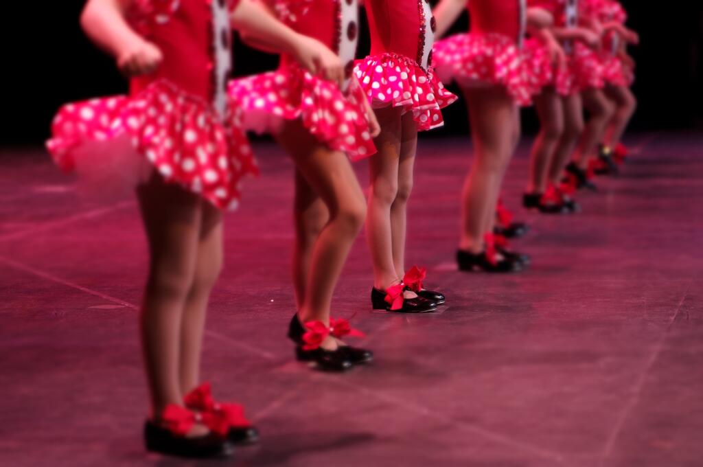 Performing on stage, a group of young dancers show off their talent and bright costumes