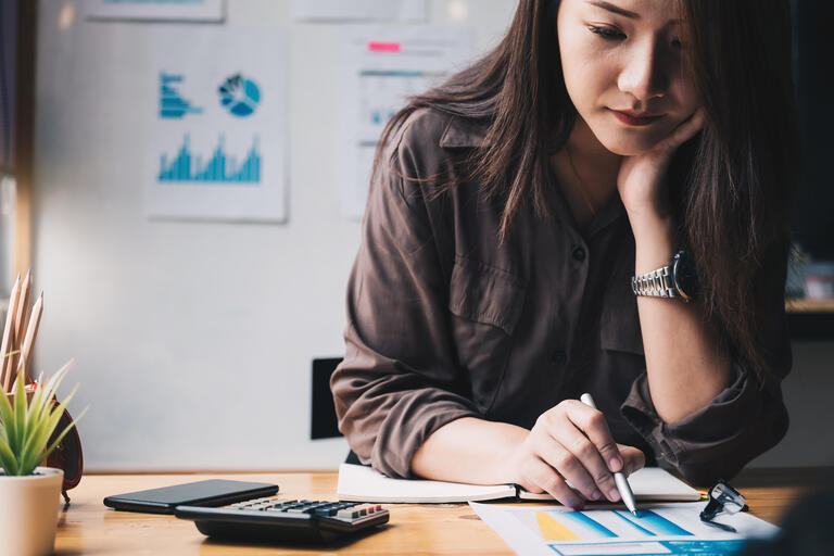 Business woman using calculator for do math finance on wooden desk in office and business working background, tax, accounting, statistics and analytic research concept