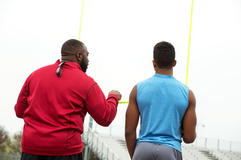 Football training day. American Football. Football coach training an athlete.